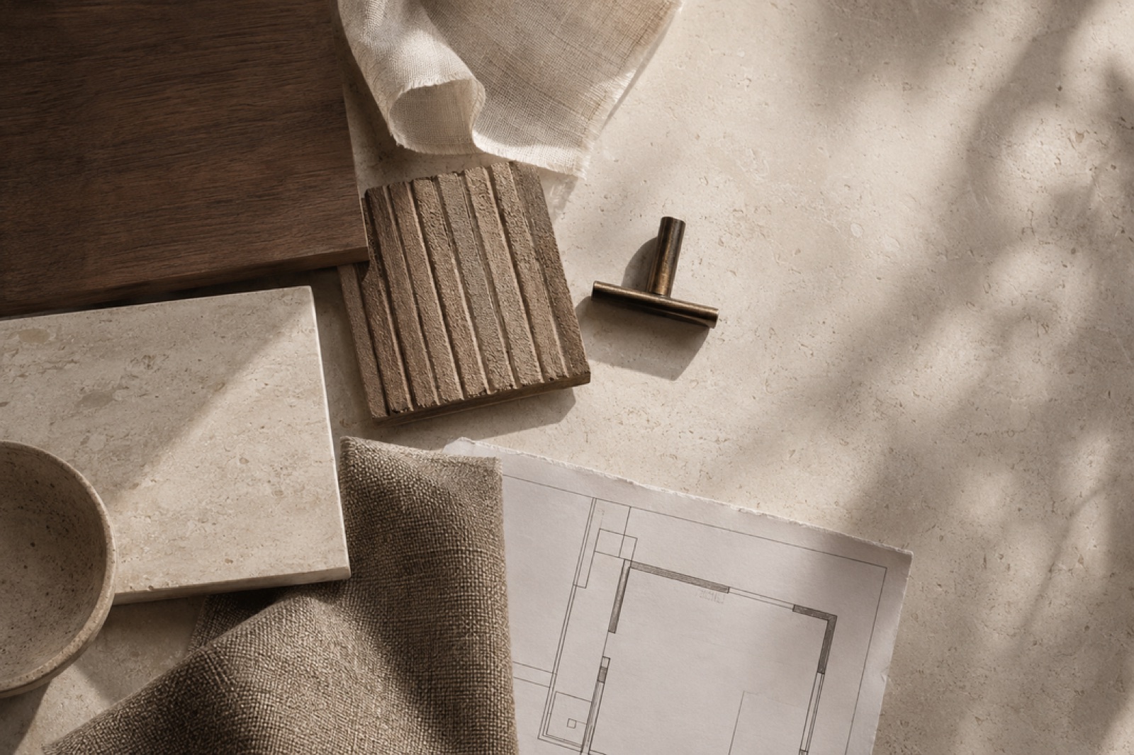 Curated flatlay of stone, timber, tile and brass samples