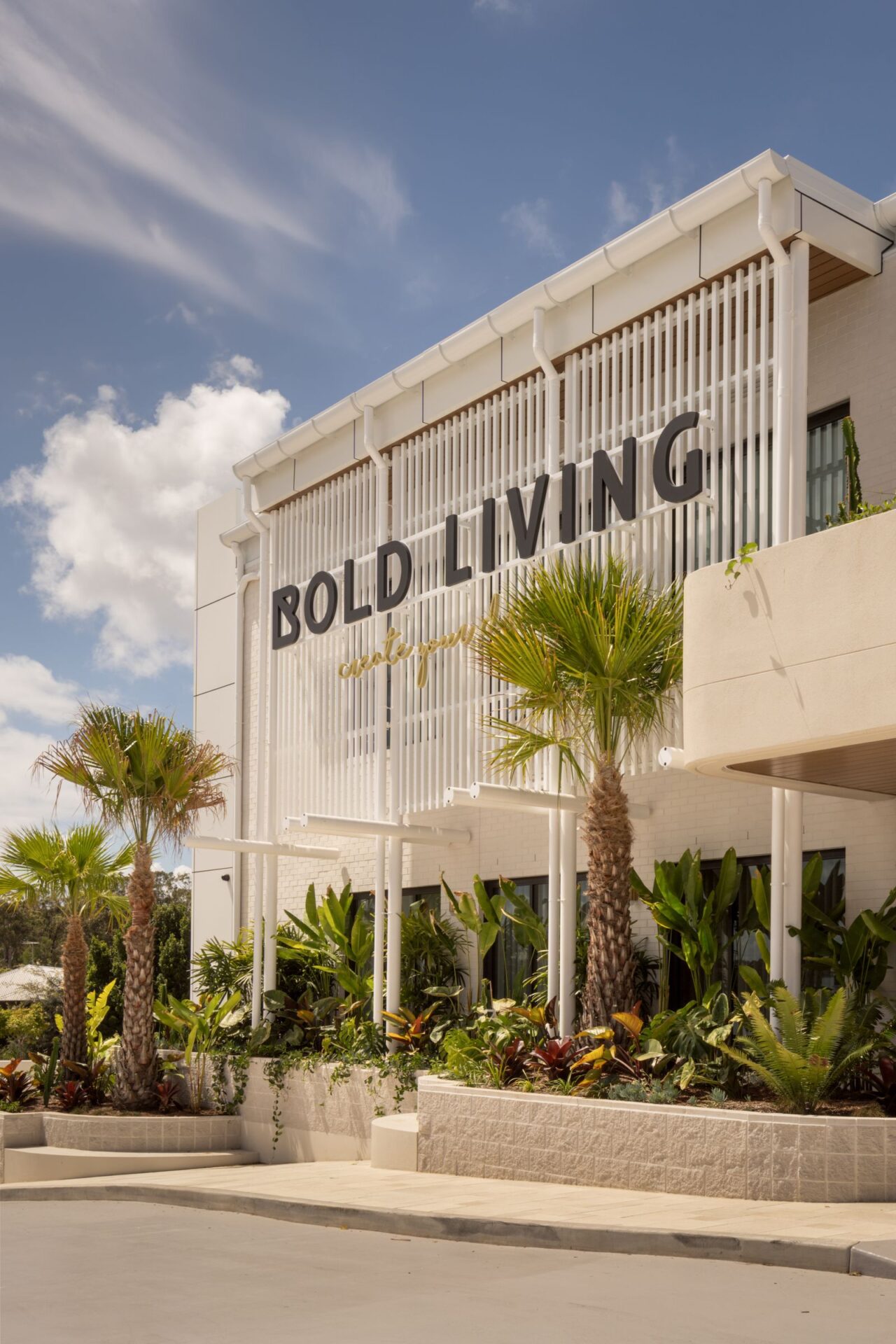 The Bold Living building on Stapylton Street with its white batten facade and palms