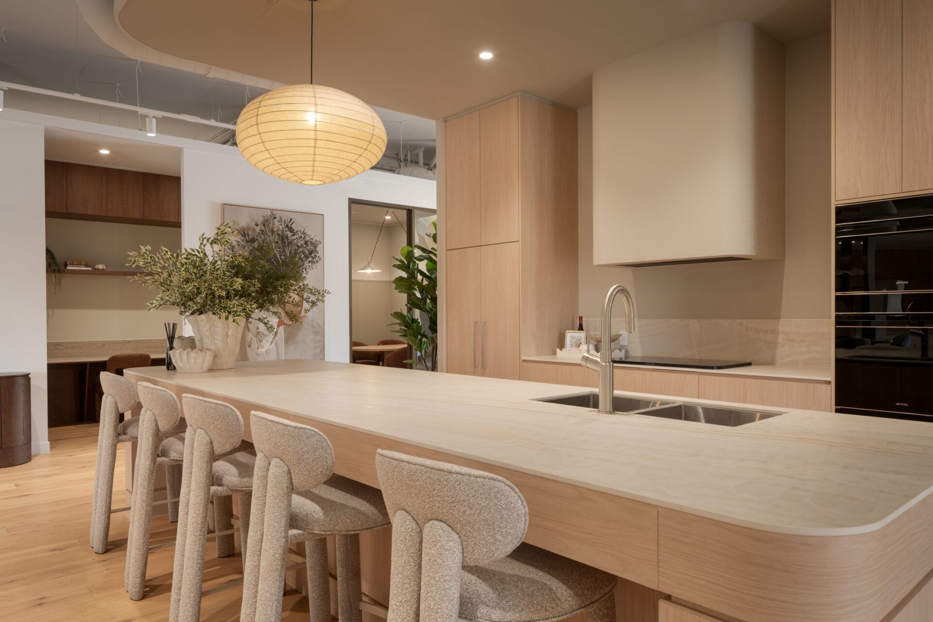 Warm oak kitchen with curved island and boucle stools