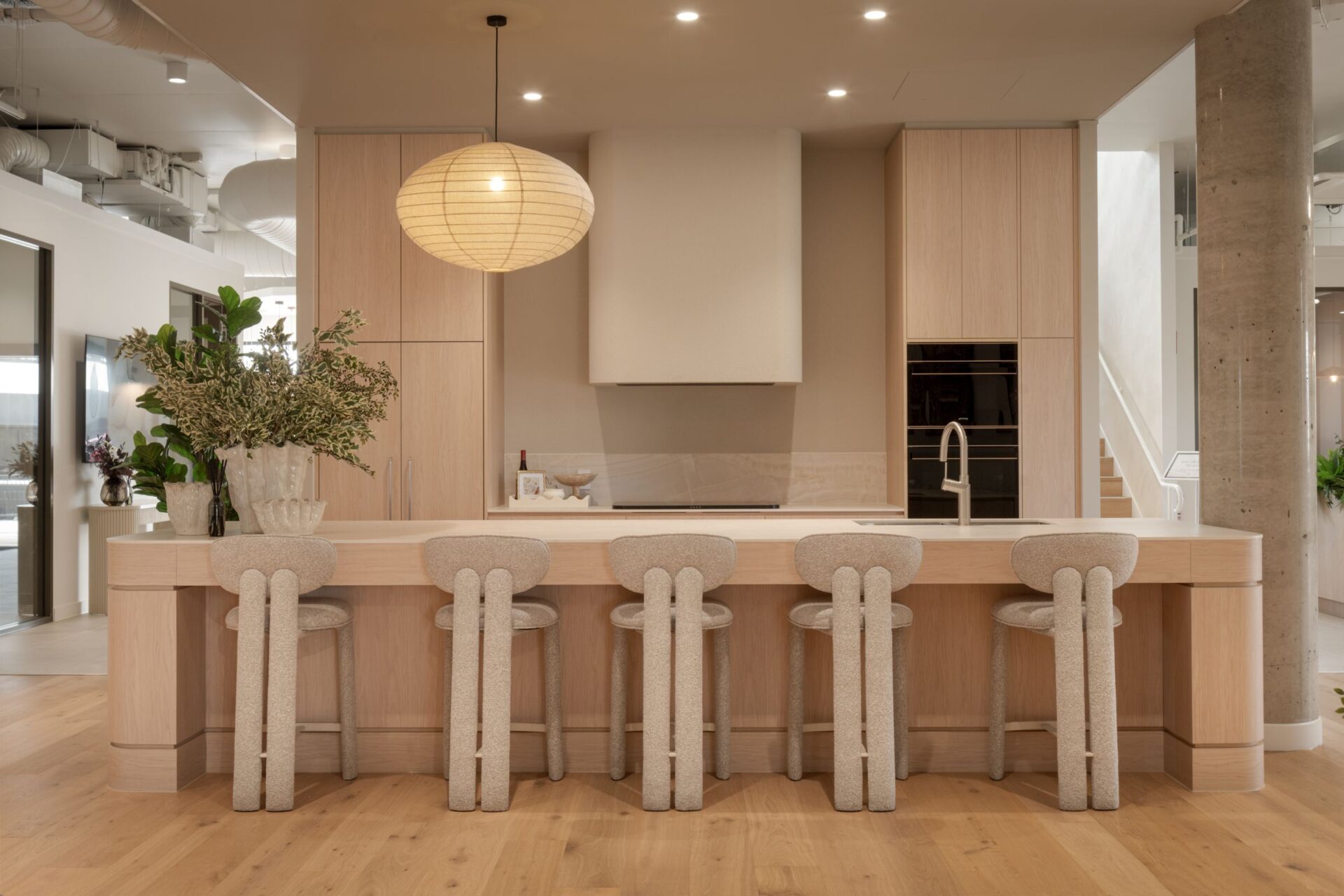 Oak display kitchen with a long island and paper pendant light